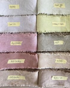 several pieces of cloth with tags on them sitting next to each other in different colors