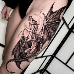 a woman's thigh with a dragon tattoo on it