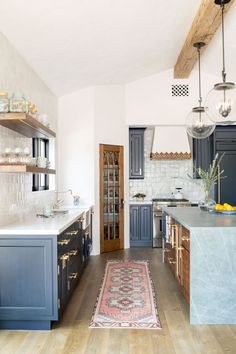 a kitchen with blue cabinets and an area rug