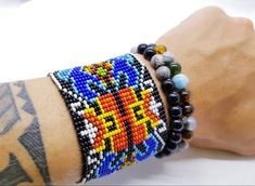 a close up of a person's arm wearing bracelets with beads and beads