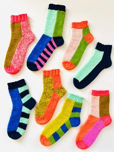 six pairs of colorful socks laid out on a white surface