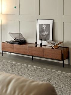 a record player on top of a wooden entertainment center in a room with white walls