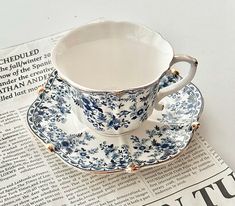 a cup and saucer sitting on top of a newspaper