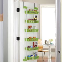 a pantry door is open and has green baskets on it