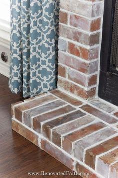 an old brick fireplace with blue and white curtains