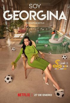 a woman in a green dress sitting on a chair next to a pool with soccer balls