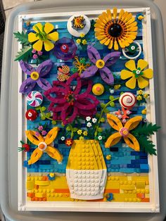 an art project made out of legos with flowers and other things on the side