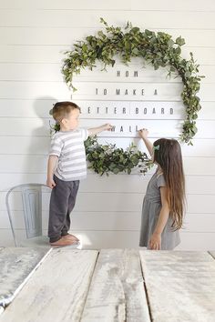 two young children standing in front of a sign that says how to make a letter board