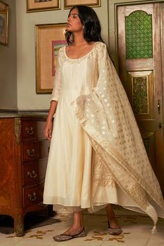 Ivory anarkali featuring sequin and pearl embroidered floral motifs on neckline. Comes with matching pant and chanderi banarasi dupatta.
Components: 3
Pattern: Embroidered
Type Of Work: Aari,Sequin,Crystal
Neckline: Round
Sleeve Type: Three quarter
Fabric: Anarkali: Chanderi,Pant: Cotton, Dupatta: Chanderi Banarasi
Color: Ivory
Other Details: 
Attached lining
Panelled anarkali
Sheer pant border
Note: Banarasi fabric will have slight variation as it is subject to availability
Occasion: Mehendi an Ivory Anarkali, Kurta Set Design, Sheer Pants, Indian Wedding Wear, Ready To Wear Saree, Indian Fashion Designers, Pernia Pop Up Shop, Embroidered Clothes, Kurta Set