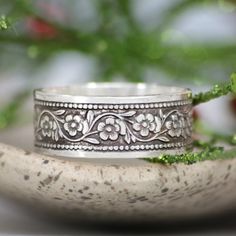 This Nature Inspired Sterling Silver Botanical Ring features a floral Daisy Chain. These bands are created with a rolling mill that embosses the pattern onto a wide strip of metal. The finished wide band measures 8 mm (approximately 0.31 inches) in width. We are happy to create this band for you in a variety of ring sizes and finishes. The intricately patterned Daisy Chain Sterling Silver band has a lovely twining Daisy Flower motif and measures 7 mm wide. The Daisy Chain band pattern continues Floral Wedding Band, Botanical Ring, Floral Wedding Bands, Rolling Mill, Silver Flower Ring, Promise Rings For Couples, Nature Inspired Rings, Sterling Silver Wedding Band, Sterling Silver Wedding Rings