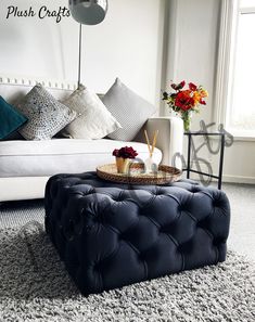 a living room with a couch, ottoman and coffee table in the middle of it