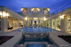 an indoor swimming pool in front of a large house