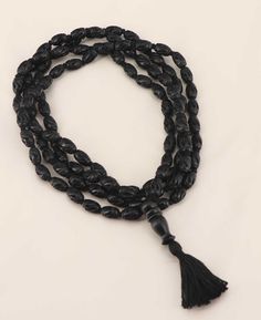 Individually carved ebony wood beads are knotted together in this handmade meditation mala. The elongated beads in this particular mala make it easier to meditate by allowing the fingers to move through the beads with ease. The use of a mala in meditation can help to focus the mind, calm the body, and deepen the practice. The mala comes in two lengths, with either 54 or 108 beads. The choice of length depends on personal preference and the intended use of the mala. The shorter 54-bead mala is of Buddha Groove, Knotted Mala, Mala Meditation, 108 Mala Beads, 108 Bead, Ebony Wood, Mala Beads, Beaded Tassels, Prayer Beads