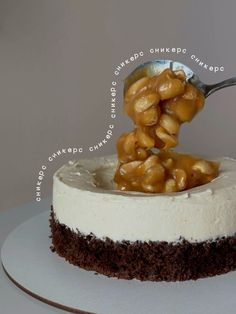 a cake with white frosting and walnuts on top is being spooned into it