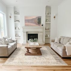 a living room with two couches and a coffee table in front of a fireplace