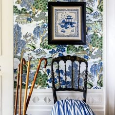 a blue and white wallpaper with an ornate chair in front of it next to two canes