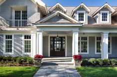 a gray house with white trim and two story windows, front steps leading up to the entry door