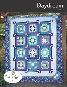 a blue and white quilt hanging from a pergolated trellis on a wooden deck