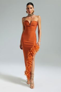 a woman in an orange dress with feathers