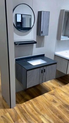 a bathroom with two sinks and mirrors on the wall next to it's cabinets