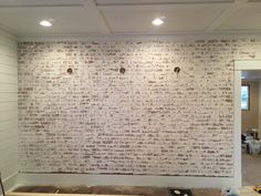 an unfinished room with white brick walls and wood flooring