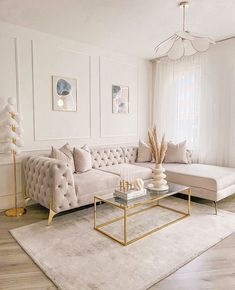 a living room with white walls and gold accents on the coffee table, couches, rugs and lamps