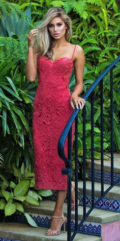 a woman in a red dress standing on stairs