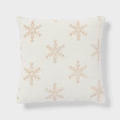 a white pillow with gold snowflakes on it