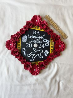 a graduation cap decorated with red flowers and writing on the side, next to a ruler