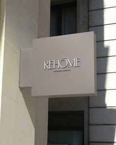 a sign that is on the side of a building saying rehome in front of it