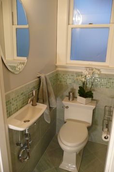 a white toilet sitting next to a sink in a bathroom