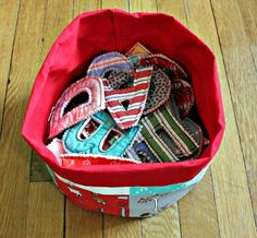 a red bag filled with lots of different types of ties on top of a wooden floor