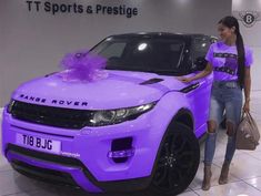 a woman standing next to a purple car