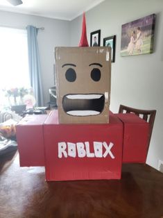 a cardboard box sitting on top of a table with a paper bag in the shape of a robot