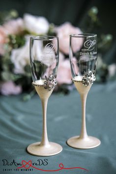 two champagne glasses with wedding decorations on them