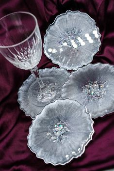 three clear glass dishes sitting on top of a purple cloth