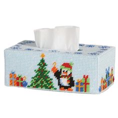 a cross stitch tissue box with a penguin and christmas tree on it