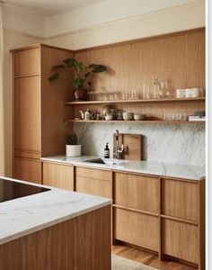 a kitchen with wooden cabinets and marble counter tops