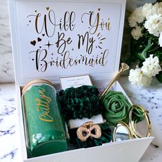 a bridesmaid gift box with personalized items in it and flowers on the side