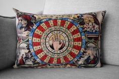 a decorative pillow on the back of a couch with an image of a hand holding a wheel of fortune