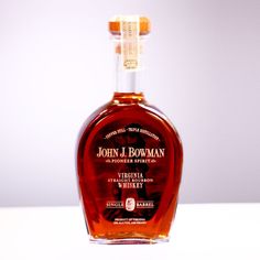 a bottle of john j bowman bourbon whiskey sitting on a table with white background