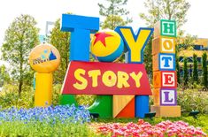 the toy story sign in front of flowers and trees