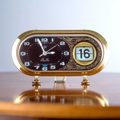 a small clock sitting on top of a wooden table