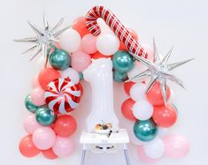 a balloon arch with candy canes, balloons and starbursts on it