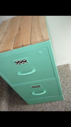 a green filing cabinet sitting on top of a carpeted floor