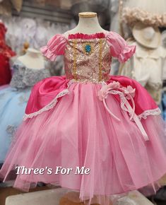 a pink and gold princess dress sitting on top of a mannequin's head