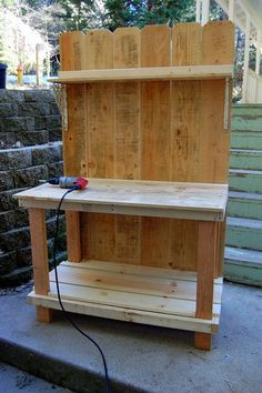 a wooden workbench sitting on the side of some steps with a power cord attached to it