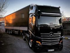 a black mercedes semi truck parked on the street