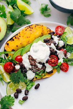 a taco filled with black beans, avocado, tomatoes and sour cream