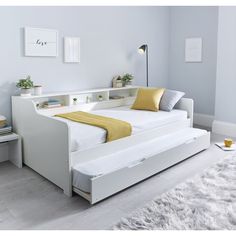 a white bed with yellow pillows in a room